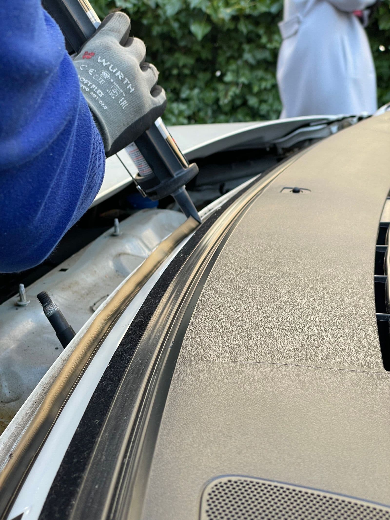 Close-up of urethane bead being applied to a windshield pinch weld