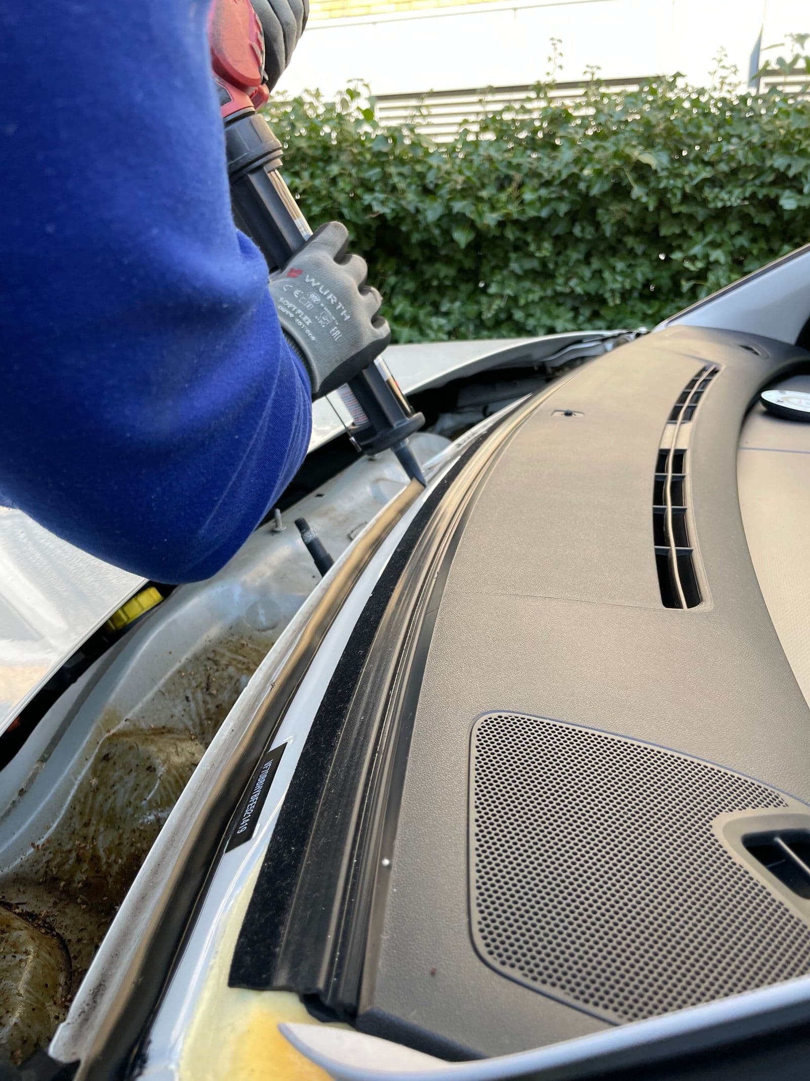 Technician setting a windshield into the pinch weld during replacement